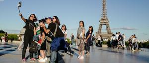 Wichtiger als die Sehenswürdigkeit ist das Selfie. Reisende vorm Eiffelturm in Paris.