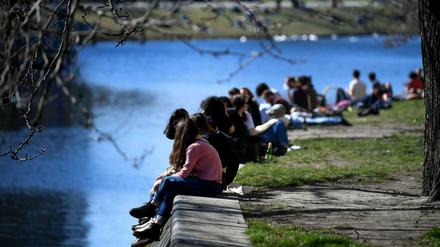 Die Menschen genießen die Frühlingssonne am Urbanhafen in Berlin.