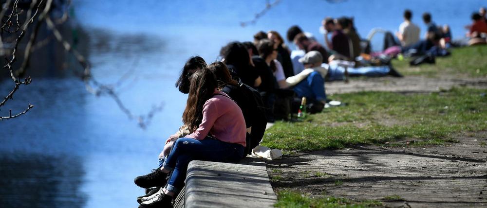 Die Menschen genießen die Frühlingssonne am Urbanhafen in Berlin.