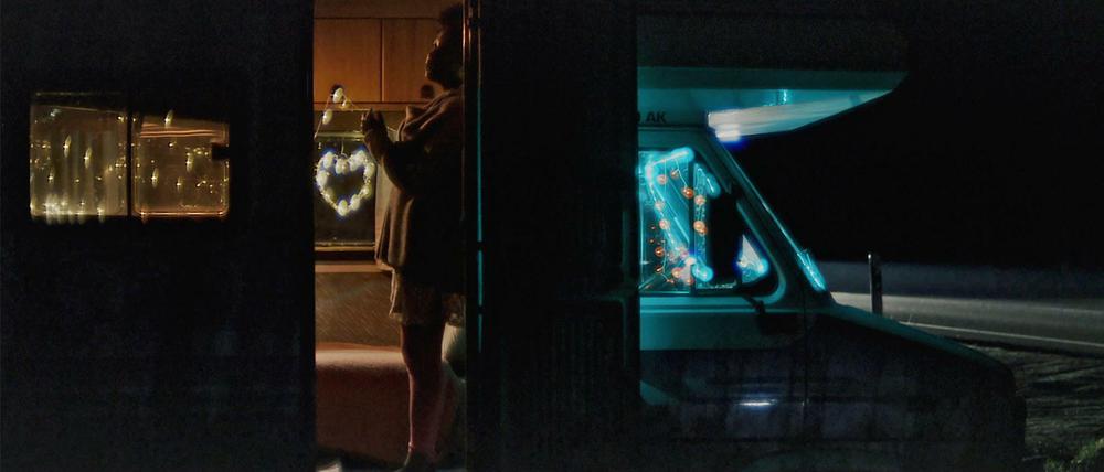 Realität? Verloren im nächtlichen Nirgendwo stehen die Wohnmobile an den Landstraßen. Szene aus dem Dokumentarfilm "Lovemobil". 