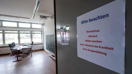 An der Tür eines Klassenzimmers stehen Corona-Regeln wie "keine Teilnahme bei Krankheit".