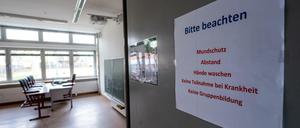 An der Tür eines Klassenzimmers stehen Corona-Regeln wie "keine Teilnahme bei Krankheit".