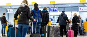 Fluggäste mit dem Reiseziel Mallorca stehen im Flughafen Hannover-Langenhagen am Check-in.