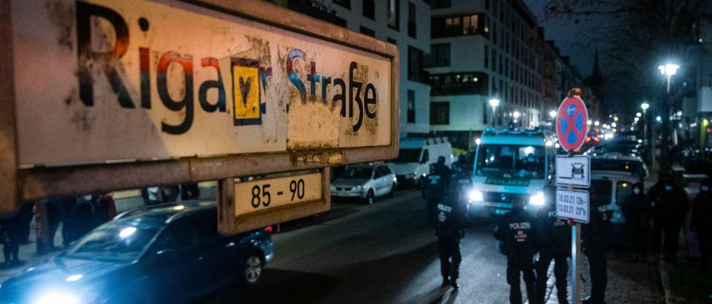 Polizisten stehen um einen Mannschaftswagen während eines Einsatzes in der Rigaer Straße.