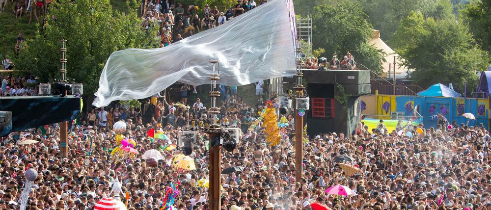 Besucher feiern die Eröffnung der Turmbühne auf dem Gelände des Fusion-Festivals 2019. 