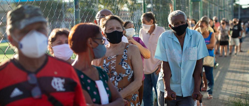 Menschen über 70 Jahren stehen Schlange vor einem Impflokal in Brasilien.