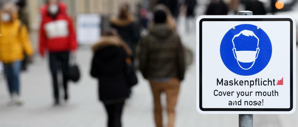Ein Schild weist in der Münchner Innenstadt auf die Maskenpflicht hin.