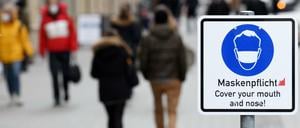 Ein Schild weist in der Münchner Innenstadt auf die Maskenpflicht hin.