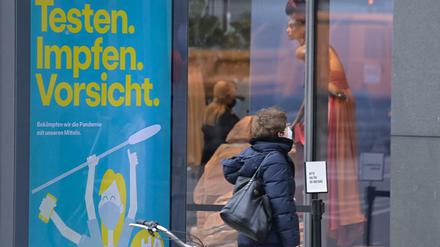 Eine Frau mit Maske vor einem Schaufenster am Kurfürstendamm.