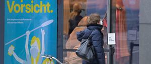 Eine Frau mit Maske vor einem Schaufenster am Kurfürstendamm.