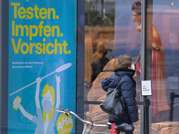 Eine Frau mit Maske vor einem Schaufenster am Kurfürstendamm.