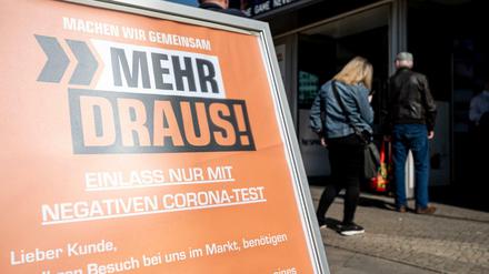 Mehr testen: Ein Schild vor einem Elektronikmarkt am Alexanderplatz.