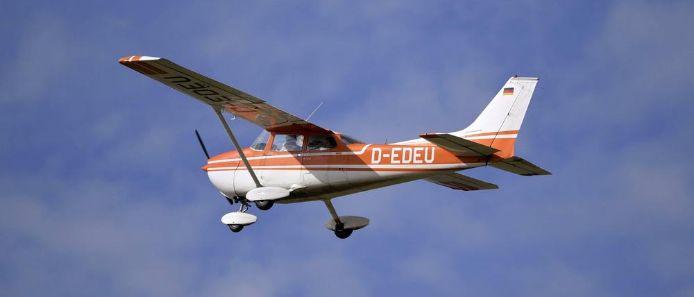 Einmotoriges Kleinflugzeug fliegt an wolkigem Himmel.