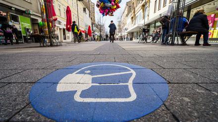 Symbol zur Maskenpflicht auf dem Pflaster der Fußgängerzone in der Offenbacher Innenstadt
