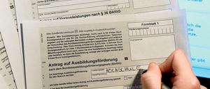 Eine Frau, deren Hand zu sehen ist, füllt einen Bafög-Antrag auf Papier aus.