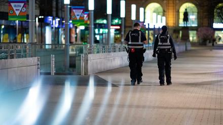 Mitarbeiter eines Sicherheitsdienstes kontrollieren die Einhaltung der Ausgangsbeschränkungen.
