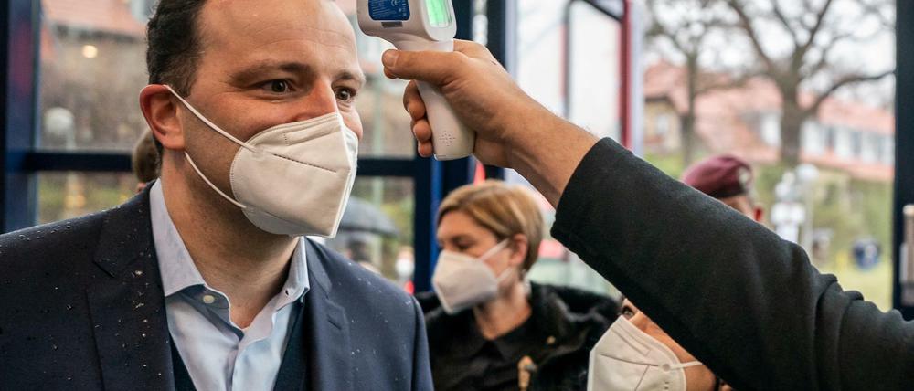 Gesundheitsminister Jens Spahn (CDU) lässt sich vor dem Besuch eines Impfzentrums die Temperatur messen.
