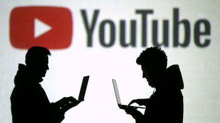 Silhouetten vor einer Projektion des Youtube-Logos.