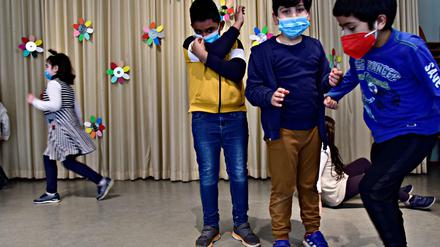 Spielende Schulkinder mit Corona-Masken.