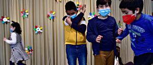 Spielende Schulkinder mit Corona-Masken.