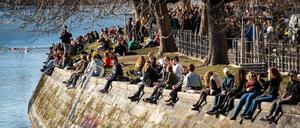 Menschen genießen am Landwehrkanal in Berlin-Kreuzberg die Sonne.