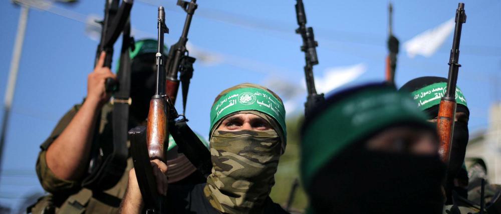 Anhänger der Hamas schwenken ihre Waffen. Die Terrororganisation ging aus der Muslimbruderschaft hervor.