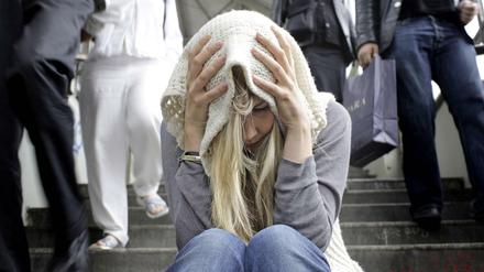 Haareraufen mit Filterfunktion. Junge Frau auf einer Treppe in Berlin. 