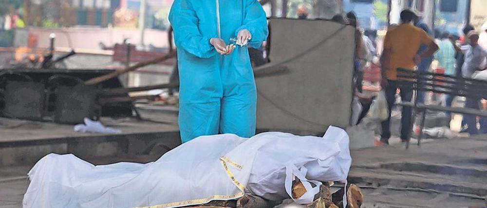 Im Ausnahmezustand. Ein Krematoriums-Angestellter in Neu-Delhi vollzieht die letzte Ölung bei einem Corona-Opfer.