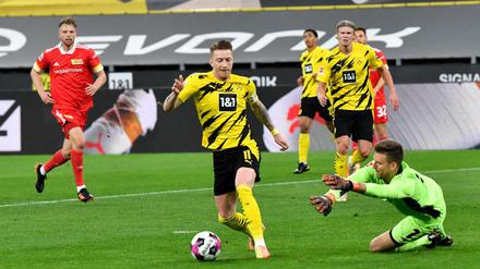 Gleich wird’s strittig. Marco Reus (vorne links) geht im Duell mit Unions Torwart Andreas Luthe (rechts) zu Boden und bekommt einen Elfmeter, der im Nachsetzen zum wichtigen 1:0 für den BVB führt. 