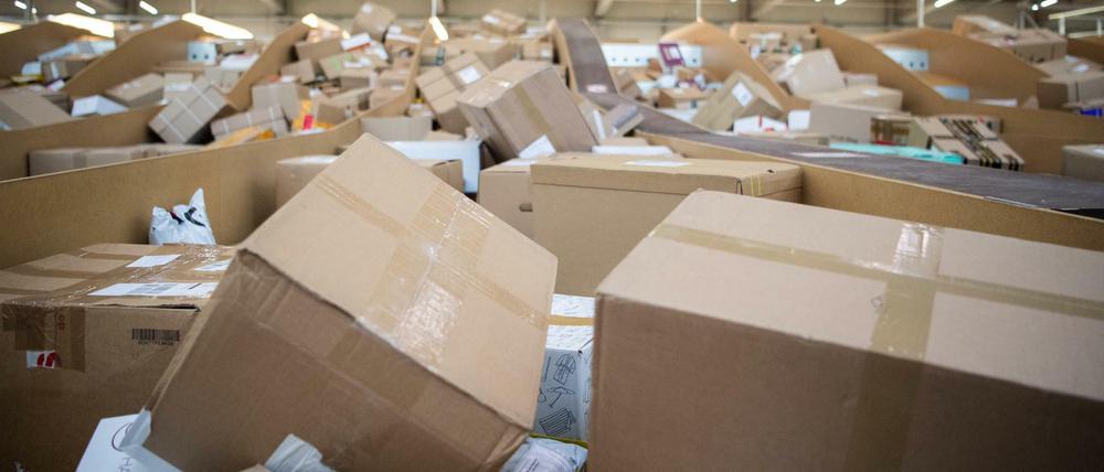 Pakete liegen in einem Paketzentrum von DHL.