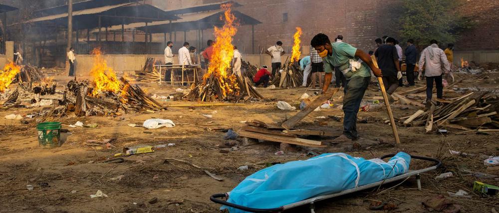 Flammende Zeichen. Scheiterhaufen brennen in Neu-Delhi über Leichnamen von Coronavirus-Opfern.