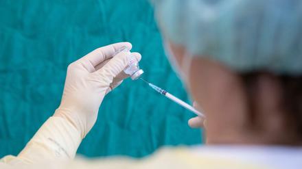 Durch, aber kein Bruch: In die sterile Gummimembran einer Impfstoffampulle sticht hier eine Krankenschwester in Bielefeld, um eine Dosis aufzuziehen.