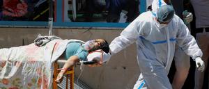 Ein Covid-19-Patient wird an einer Klinik in Neu Delhi transportiert.