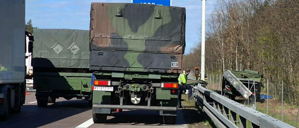 Ein Lastwagen der Bundeswehr steht auf dem Standstreifen der A2, während rechts neben der Fahrbahn ein beschädigtes Fahrzeug liegt.