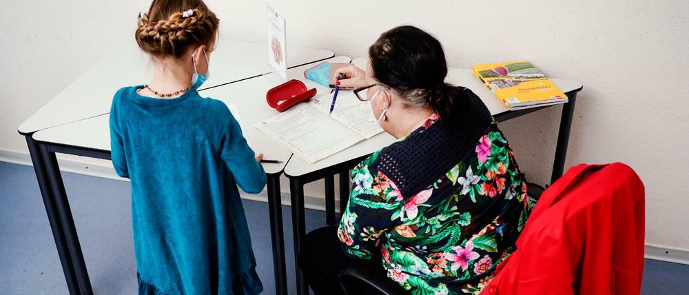 Eine Nachhilfelehrerin übt mit einem achtjährigen Mädchen in einer Nachhilfeschule.