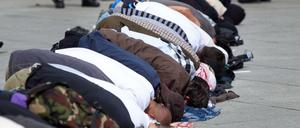 Beten auf dem Potsdamer Platz. Salafisten geben sich gerne demonstrativ fromm. Einige können jedoch offenbar tiefen Glauben mit kriminellen Aktivitäten vereinbaren 