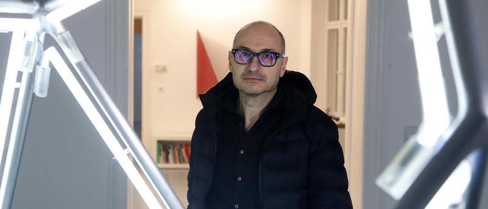 Albert Weis hinter seiner Lichtskulptur „parts (alaska)“, gefertigt aus Aluminium und Neon, in der Galerie Taubert.