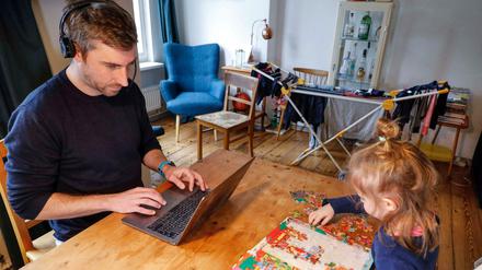 Der Traum vom Homeoffice hat Glanz verloren: Vater mit Tochter bei der Arbeit zu Hause. Andere haben ihre Jobs verloren.