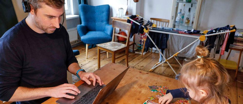 Der Traum vom Homeoffice hat Glanz verloren: Vater mit Tochter bei der Arbeit zu Hause. Andere haben ihre Jobs verloren.