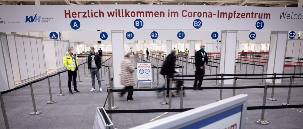 Zwei Senioren (M) sind im Eingangsbereich des Corona-Impfzentrums in den Hamburger Messehallen auf dem Weg zur Impfung. Dort erfolgt das Gros der Hambuger Corona-Schutzimpfungen.