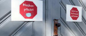An der Eingangstür einer Schule kleben Schilder, die auf die Maskenpflicht hinweisen und auf den "Zutritt nur für Personal und Schüler".