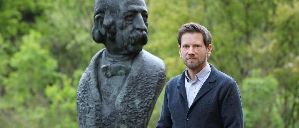 Peer Trilcke, der Leiter des Potsdamer Fontane Archivs vor einer Büste des Dichters