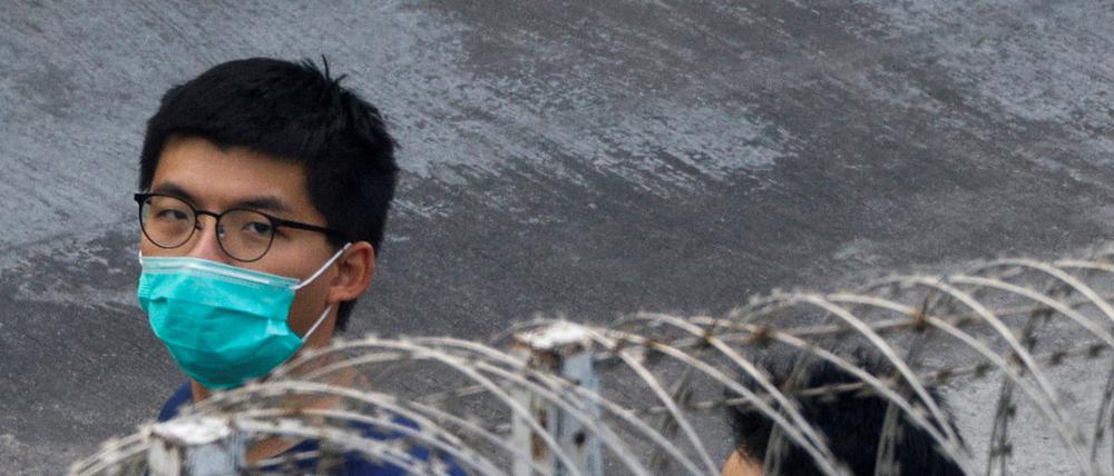 Der Hongkonger Aktivist Joshua Wong (links) hinter Stacheldraht (Archivbild von Dezember 2020)