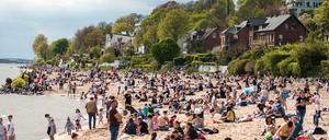 Hamburg: Zahlreiche Menschen sind bei Sonnenschein am Elbstrand in Övelgönne unterwegs.