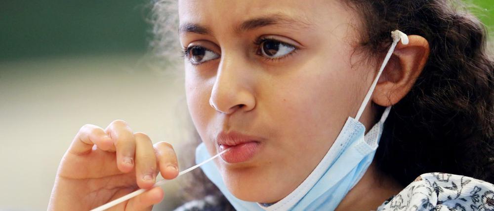Eine Schülerin macht den "Lolli-Test in Nordrhein-Westfalen