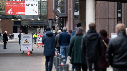 Menschen warten am Ostersonntag vor einem Impfzentrum in Köln.