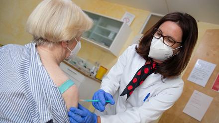 Eine Hausärztin impft eine Patientin gegen Corona.