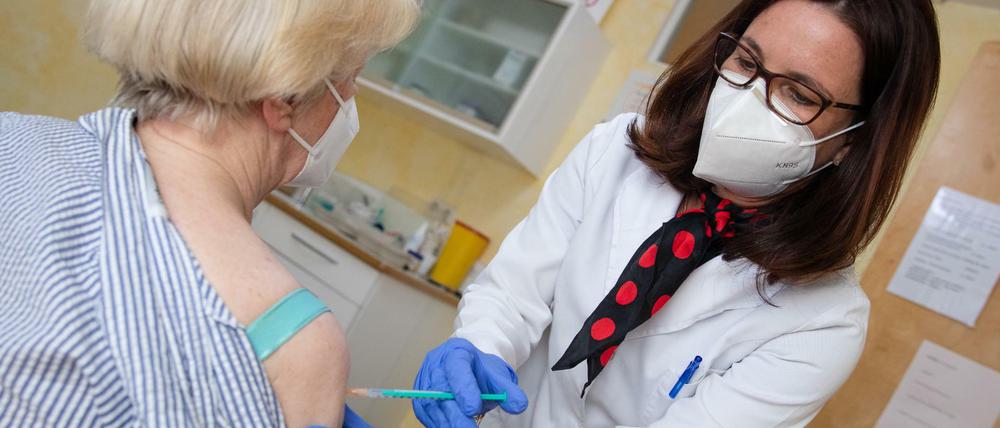 Eine Hausärztin impft eine Patientin gegen Corona.