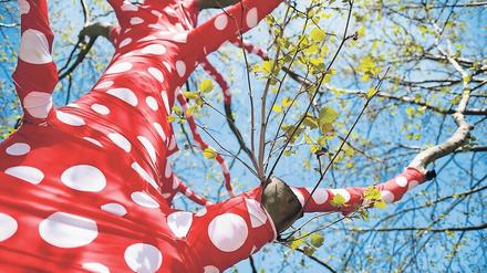 Verwandlung der Welt. Im Rahmen der Ausstellung „Yayoi Kusama. Eine Retrospektive“ wurden Bäume am Gropius Bau für die Installation „Ascension of Polka Dots on Trees“ mit rotgepunkteten Bändern umwickelt.