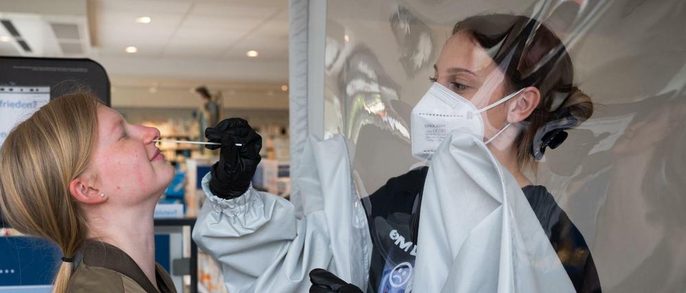 Ein Frau wird in einer Apotheke auf das Coronavirus getestet.